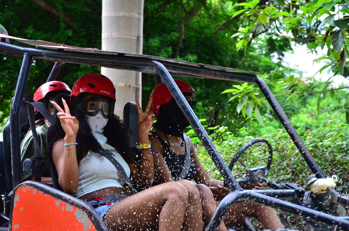Buggy passengers riding through tropical trail water