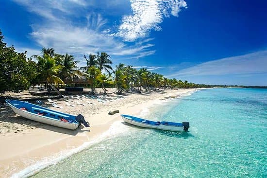 Small boats along a bright tropical island shoreline